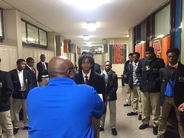 3D mentoring a group of students in a school hallway